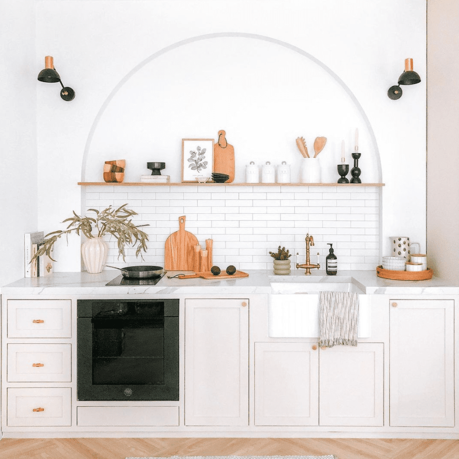 一个小的白色厨房，拱门雕刻在墙上