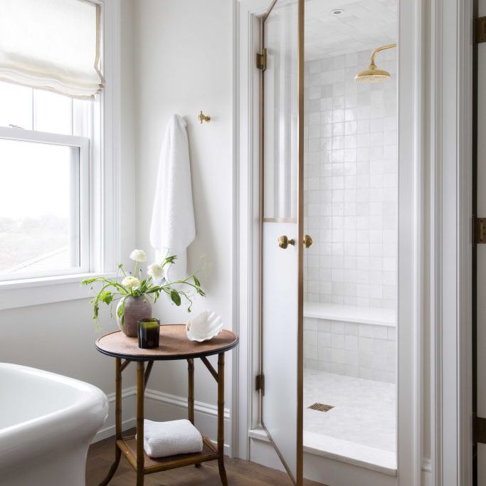 一间带小木舌桌的全白色浴室