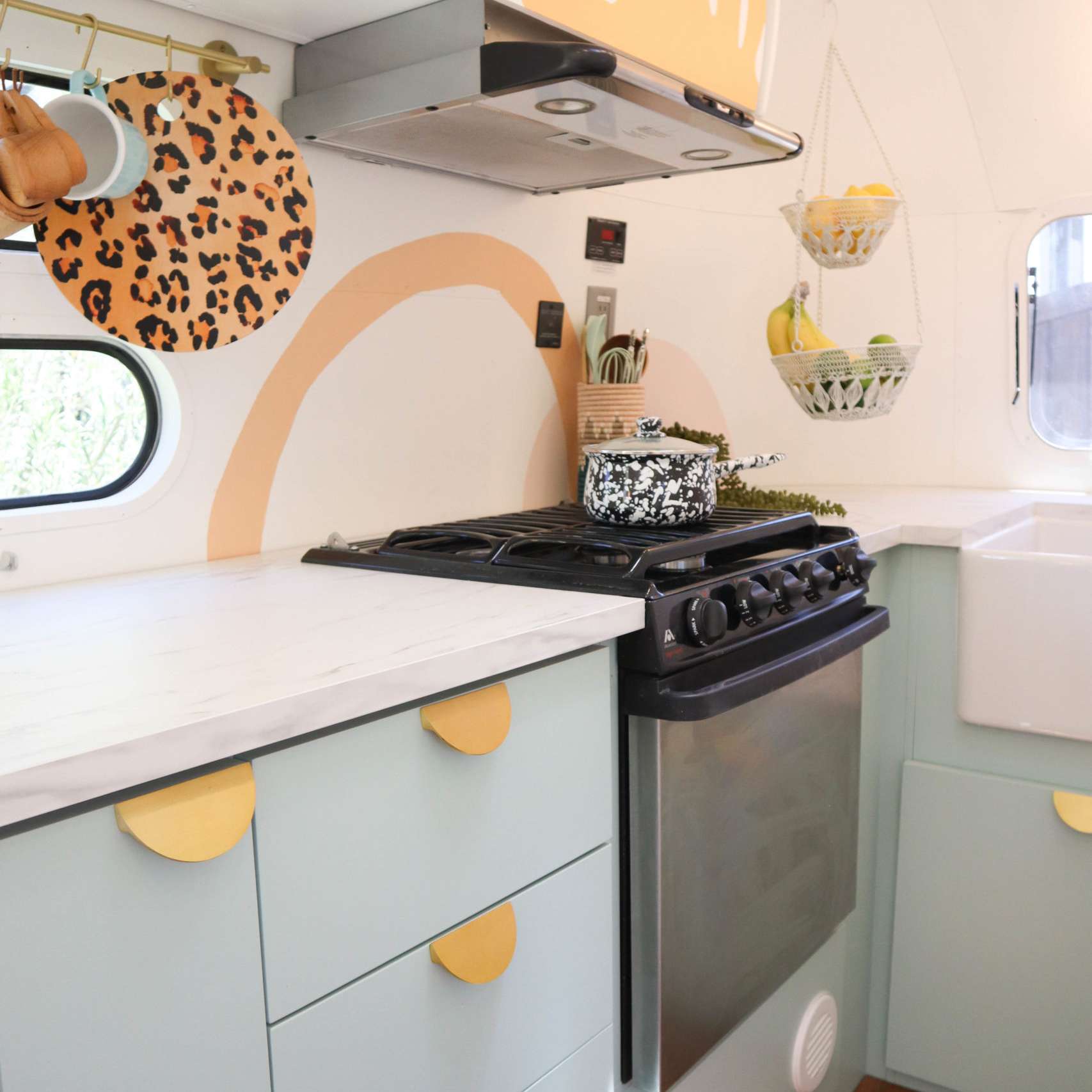 厨房里有蓝色的橱柜和金色的半月形五金。