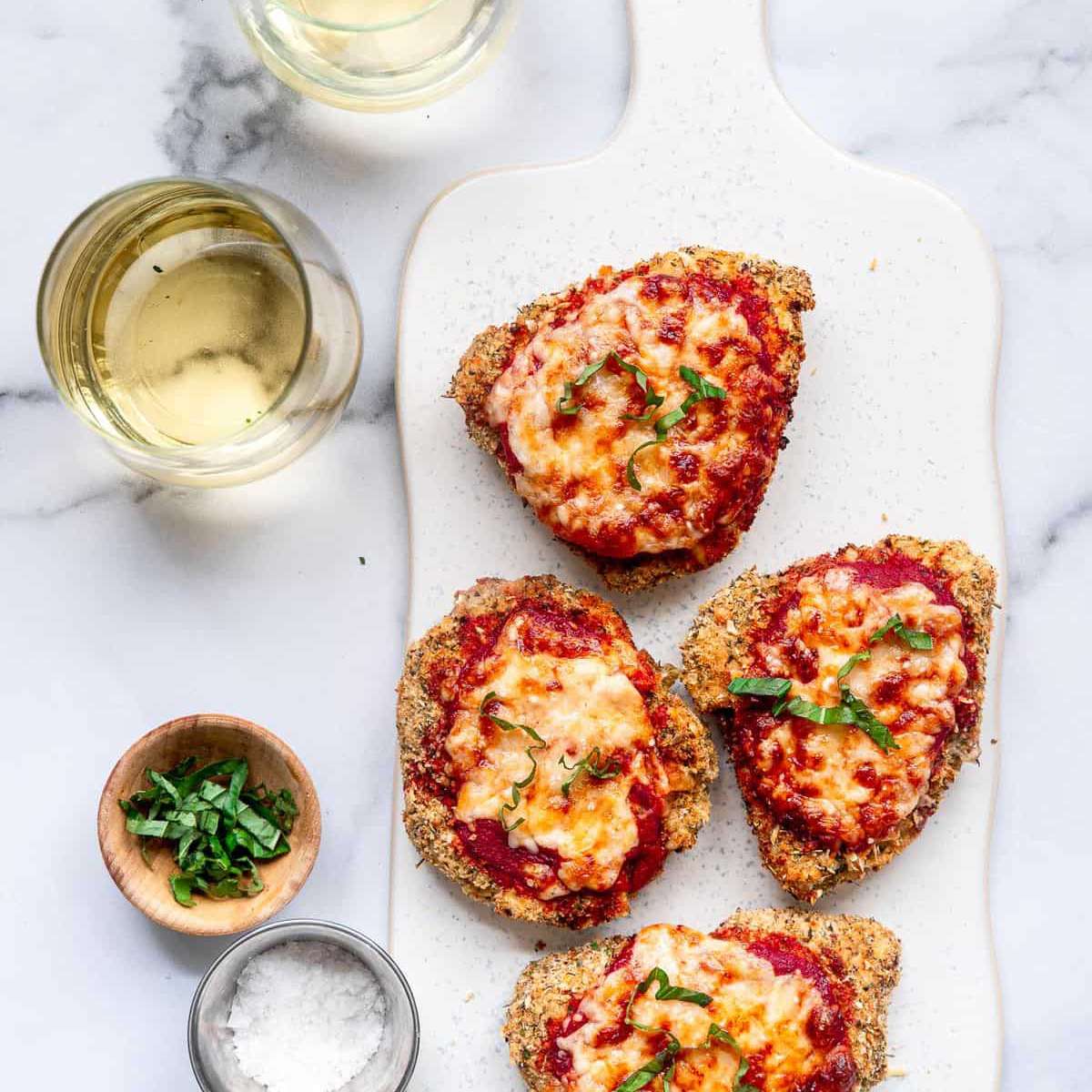 四份帕尔马鸡肉装在大浅盘里