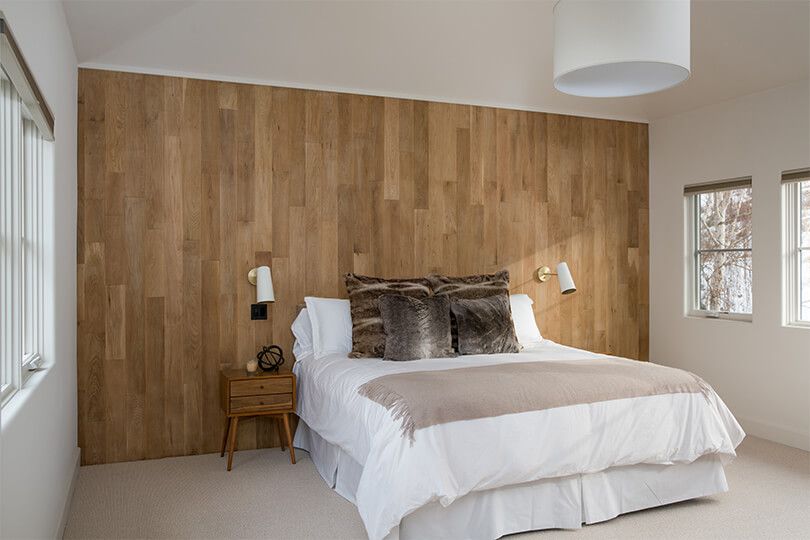 一间带木板墙壁和人造毛皮枕头的卧室