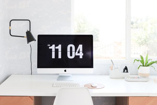 简约办公室空间与白色书桌和椅子。