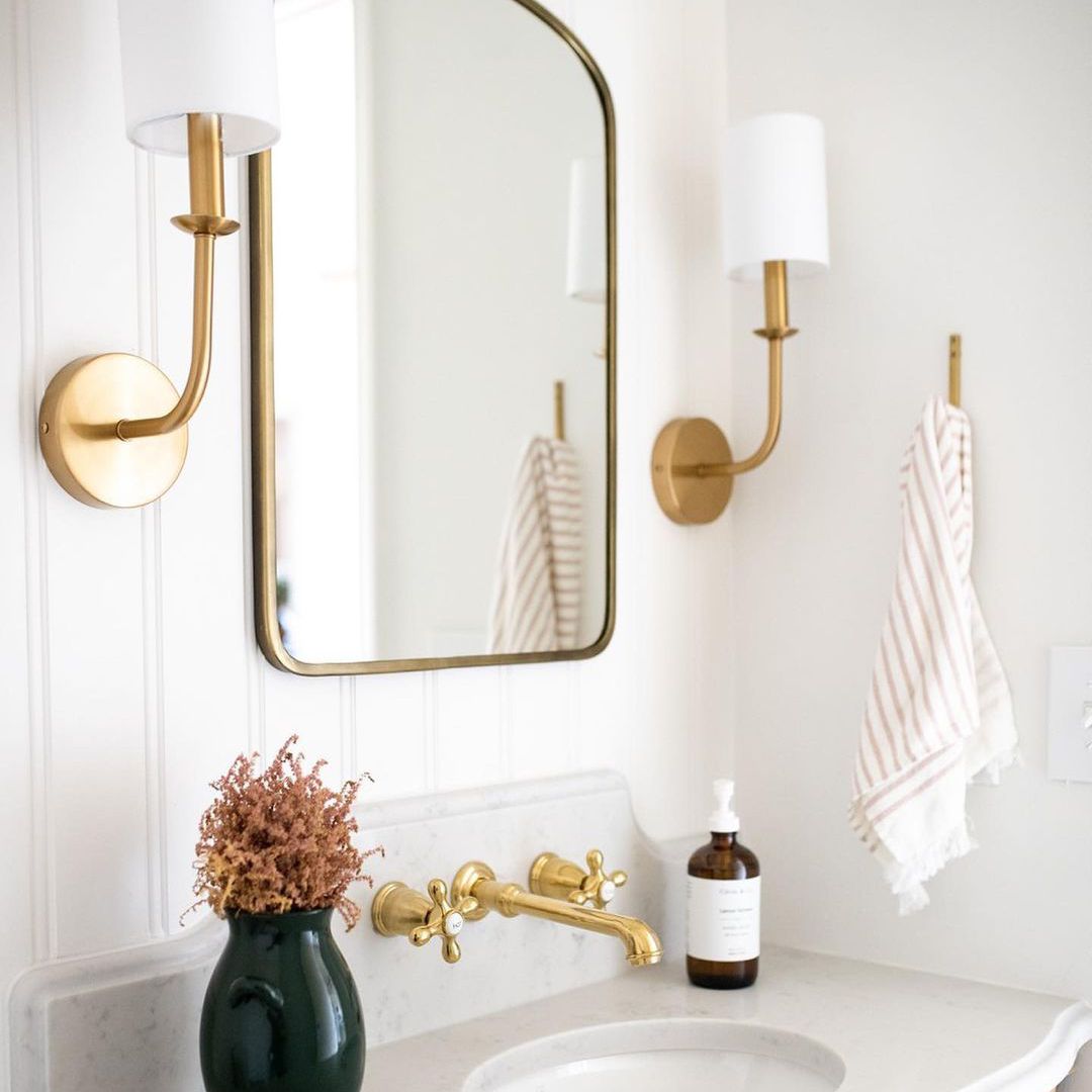 白色串珠板浴室与金色的口音。