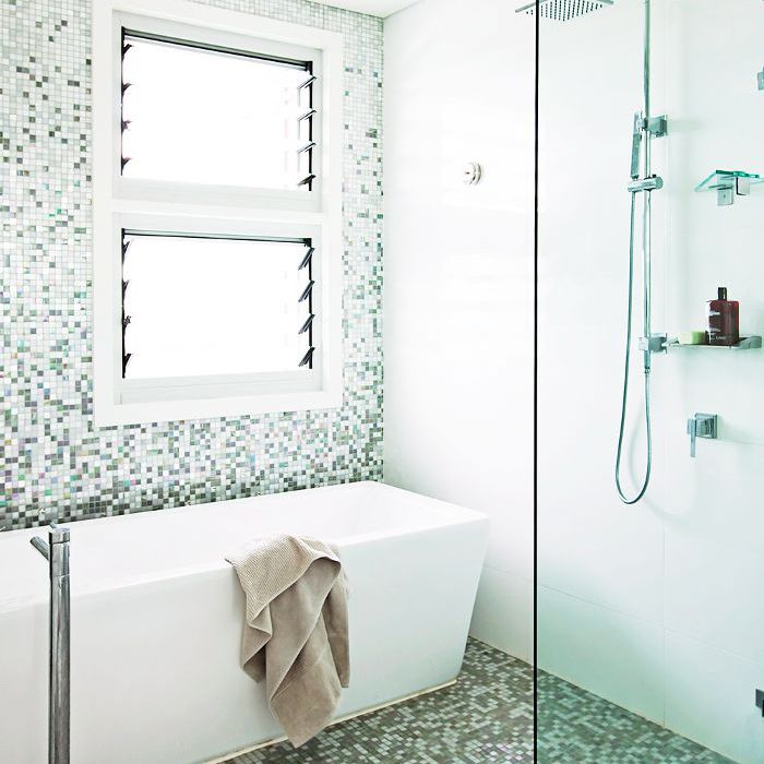 在地板和墙壁的绿色闪光的马赛克风格瓷砖的白色现代浴室。