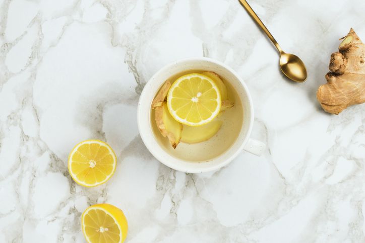 健康饮料与柠檬和新鲜的生姜根大理石背景