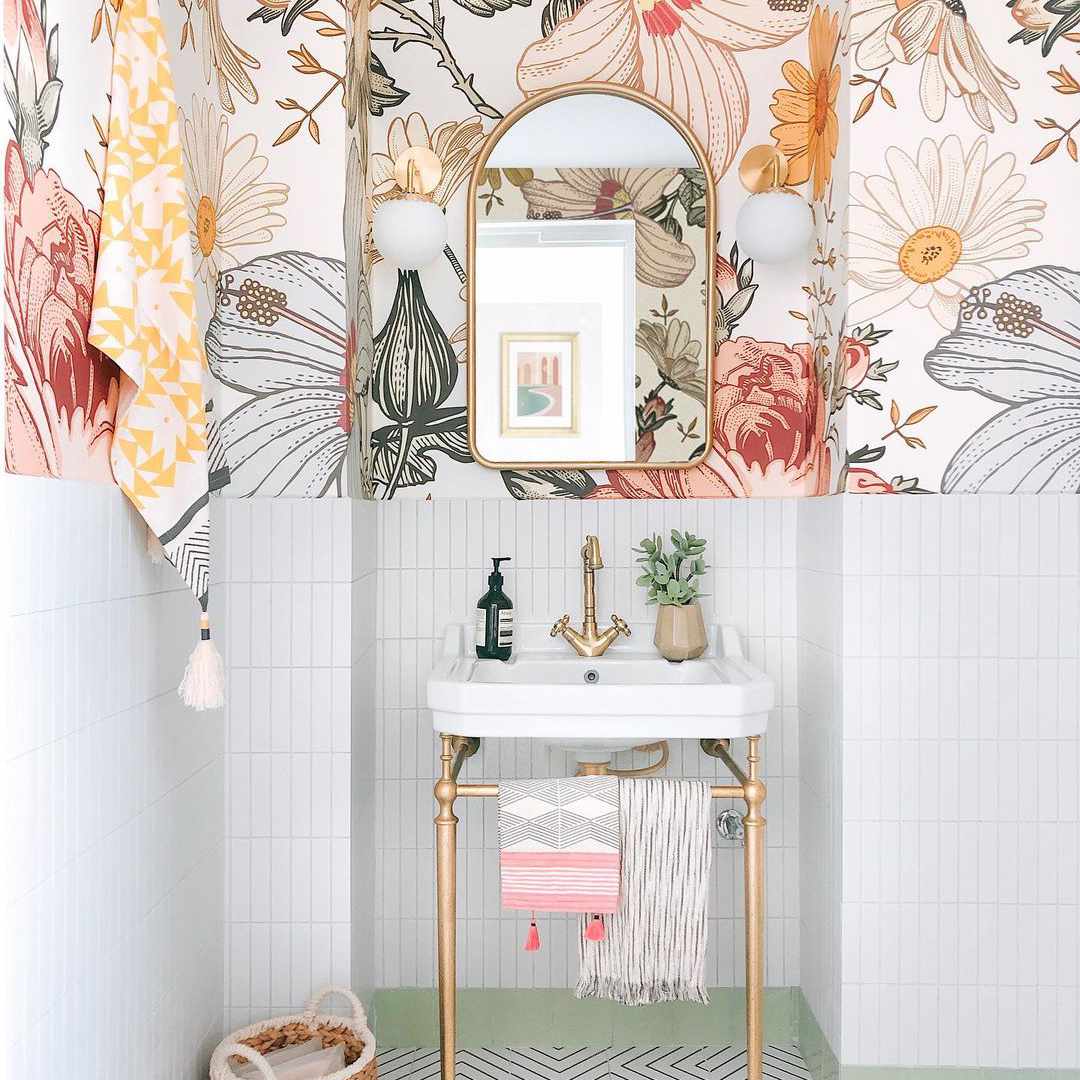 有花墙纸和金色镜子的浴室