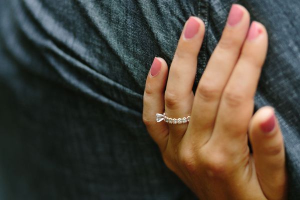 一个手指上戴着戒指的女人抱着一个男人的胳膊