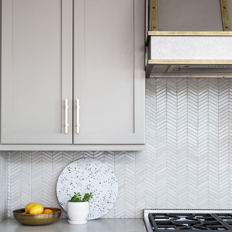 厨房里有浅灰色的橱柜和银色的电器