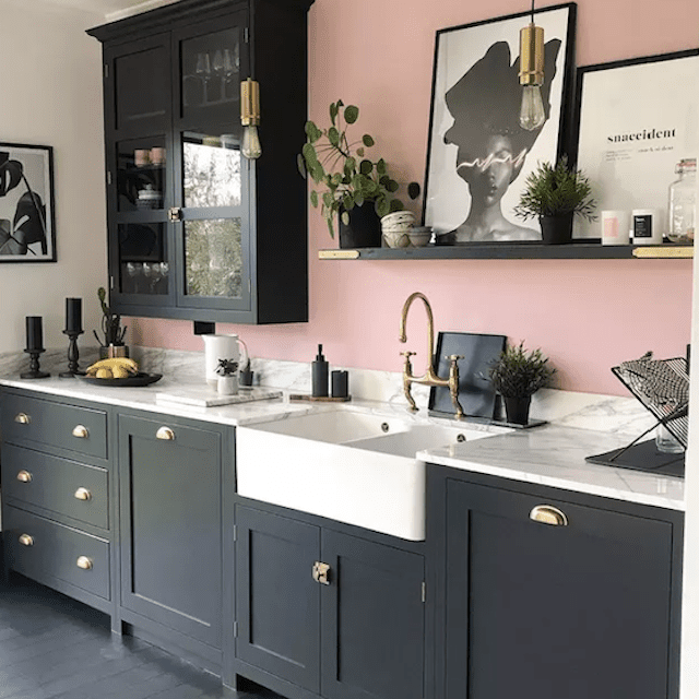 厨房里有黑色的橱柜和粉红色的墙壁