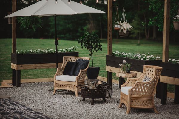 后院有两个沙发和种植包围的保护伞