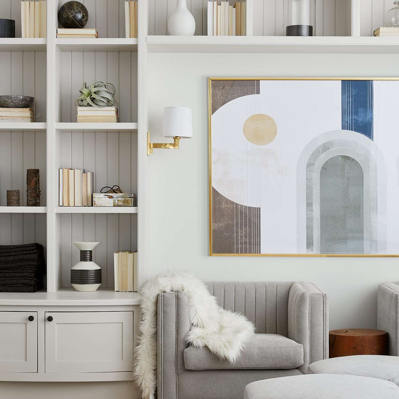 带有白色书架衬里墙壁的起居室，已装饰有书籍和小玩意