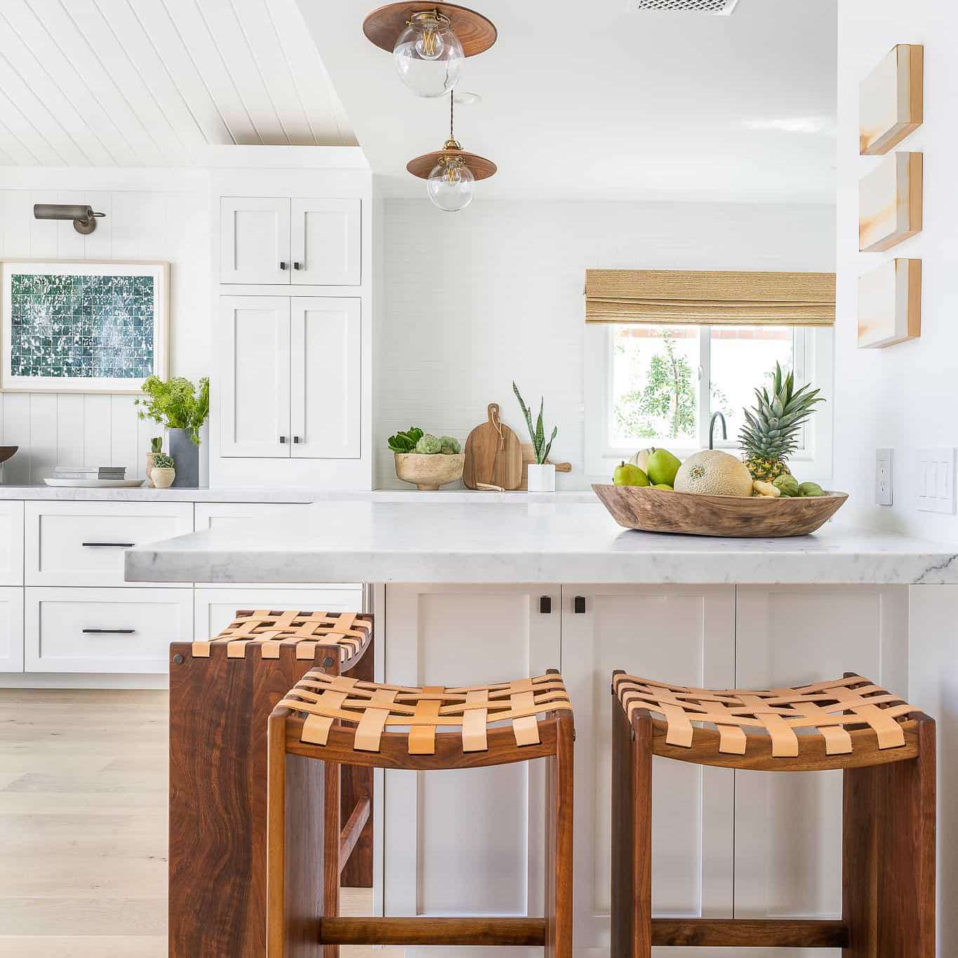 一个带有条形角的小白色厨房，被变成了一个餐厅的餐厅