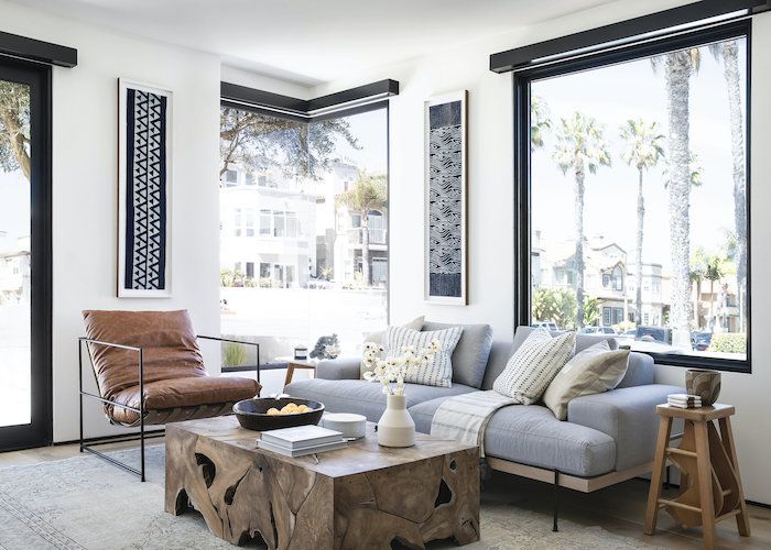 海滩现代客厅与棕色和浅蓝色调色板，皮革口音椅子