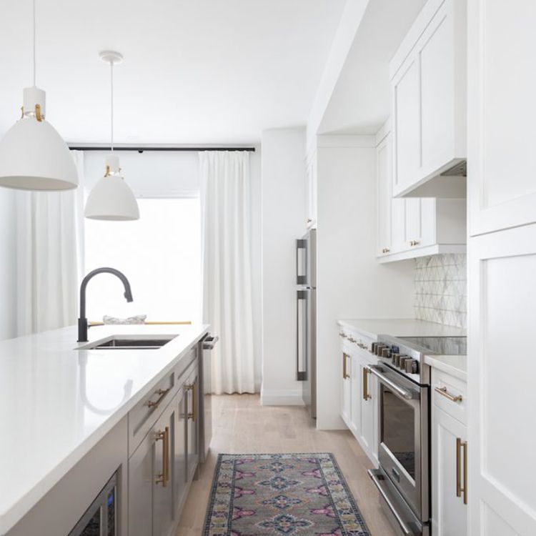 白色的厨房里铺着灰色的印花地毯