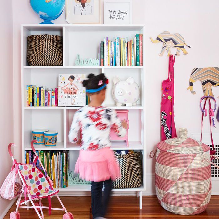 一个小女孩在她的房间由一个书柜