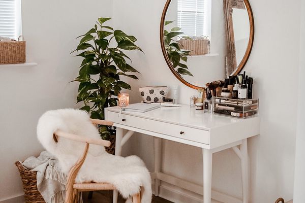 甜美的boho梳妆台与大圆形镜子和汉币椅子。