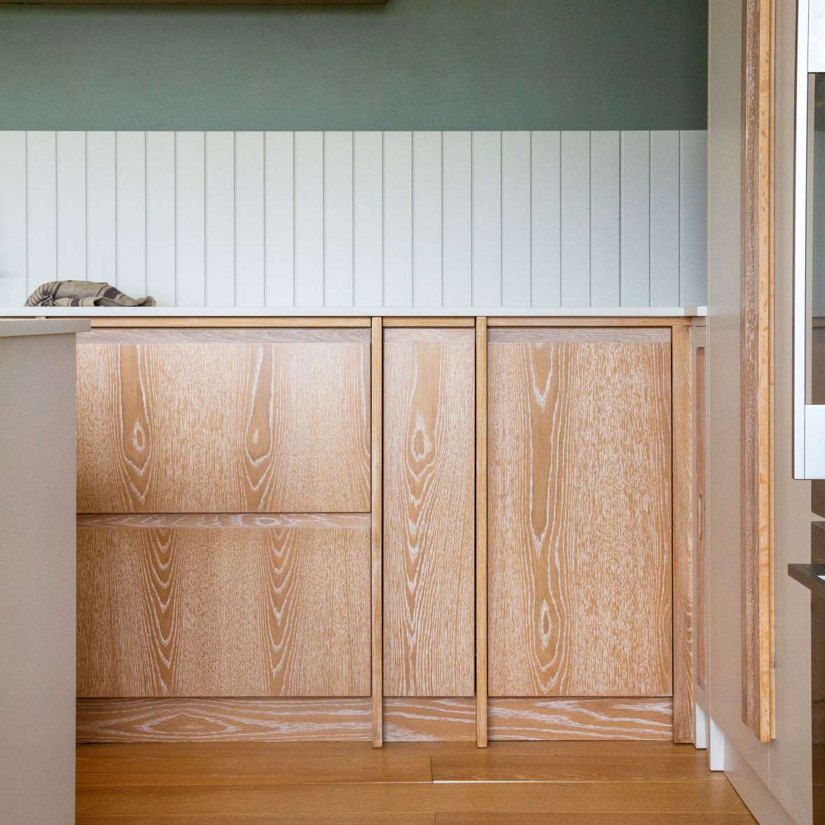 厨房里有浅色的硬木和木质橱柜，这些橱柜已经被染色，看起来更有质感