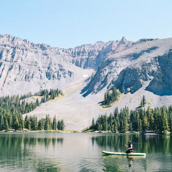 个人对桨板中的水体与背景山