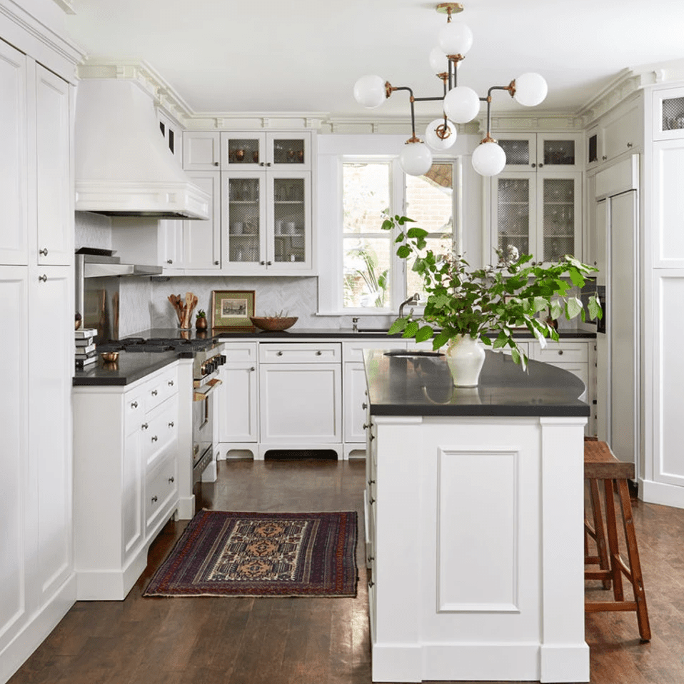 一个白色的小厨房，从天花板到地板排列着许多橱柜