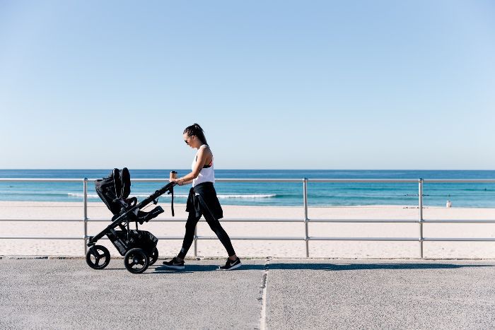 一个女人走了推车上沿海滩人行道