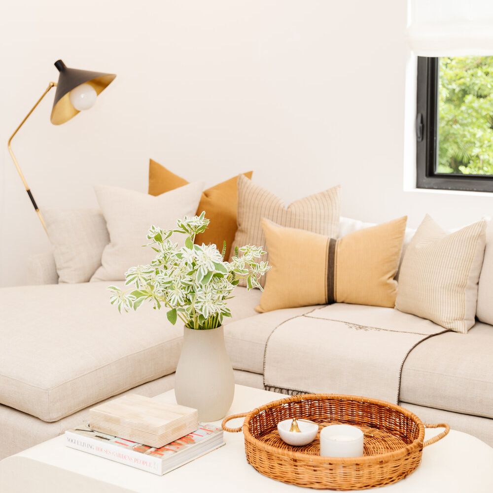 浅米色沙发和橙色枕头。