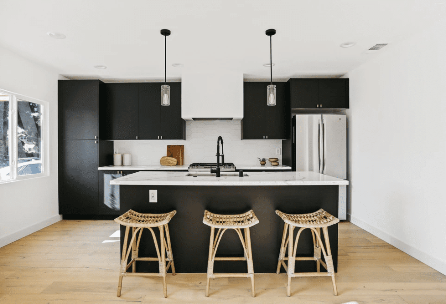 带黑色橱柜的厨房和白色的背板，从六角形瓷砖制作