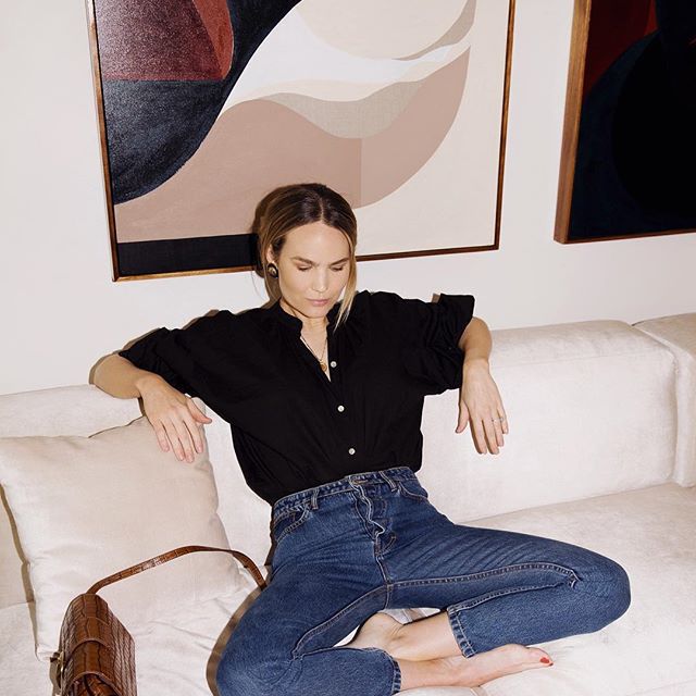 一个女人闭着眼睛，双腿交叉坐在沙发上沉思。