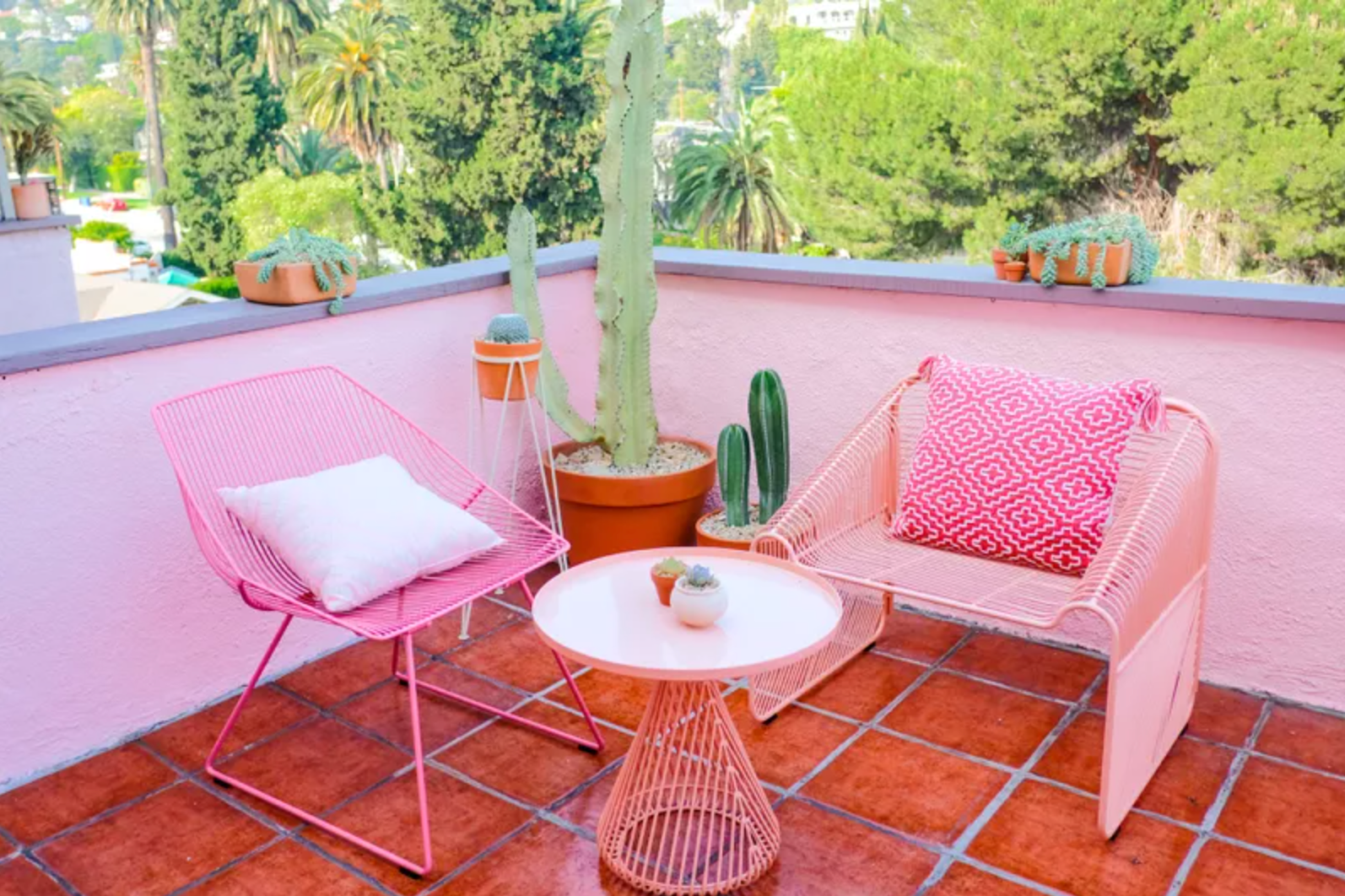 阳台上有红色的瓷砖地板，粉红色的墙和粉红色的家具
