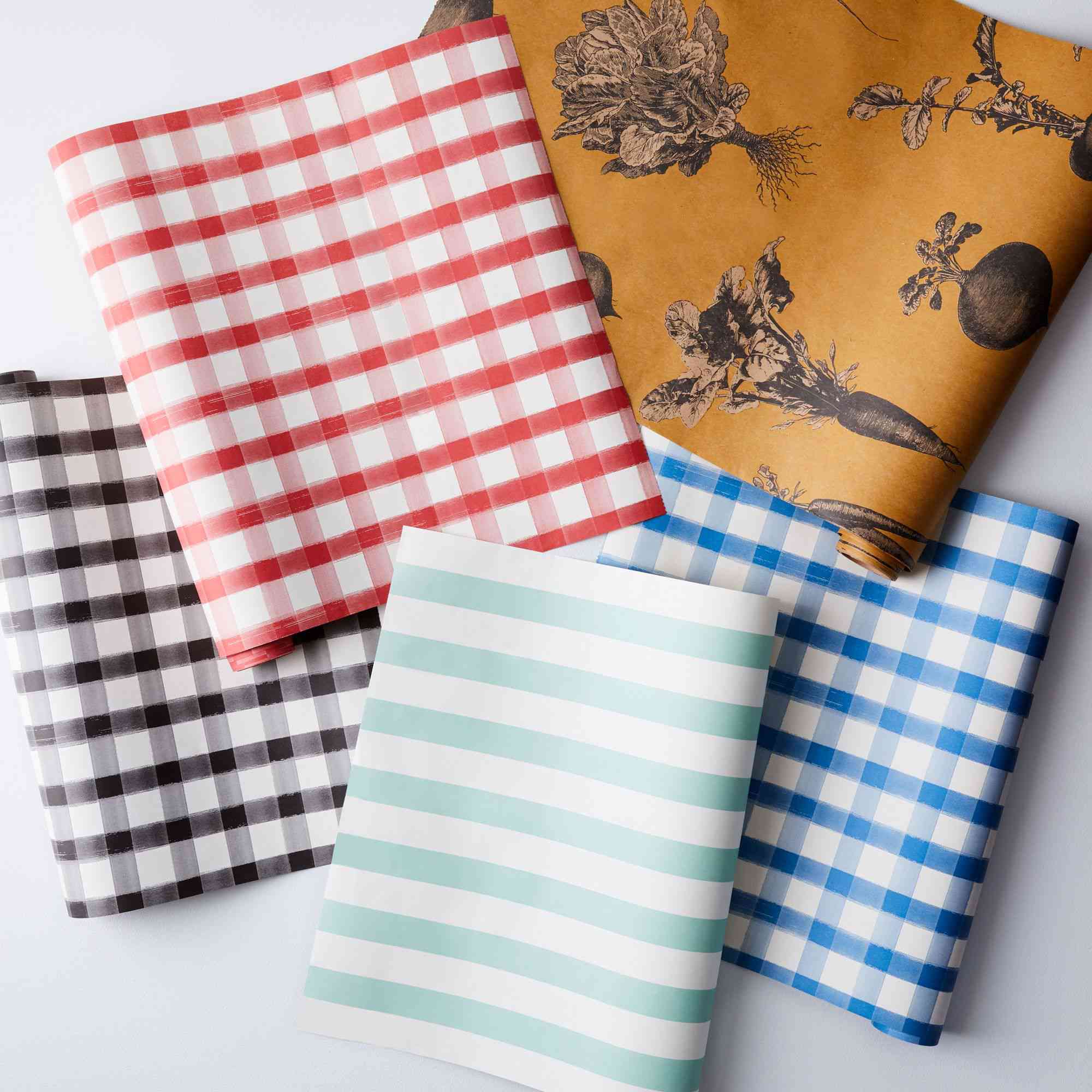 精选的红色，棕色和蓝色格子纸桌布旁边的橙色和白色和水产条纹之一。