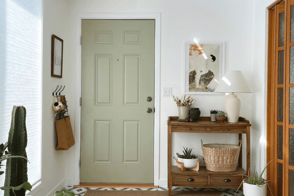 鼠尾草绿色门旁边的天然木材装饰。