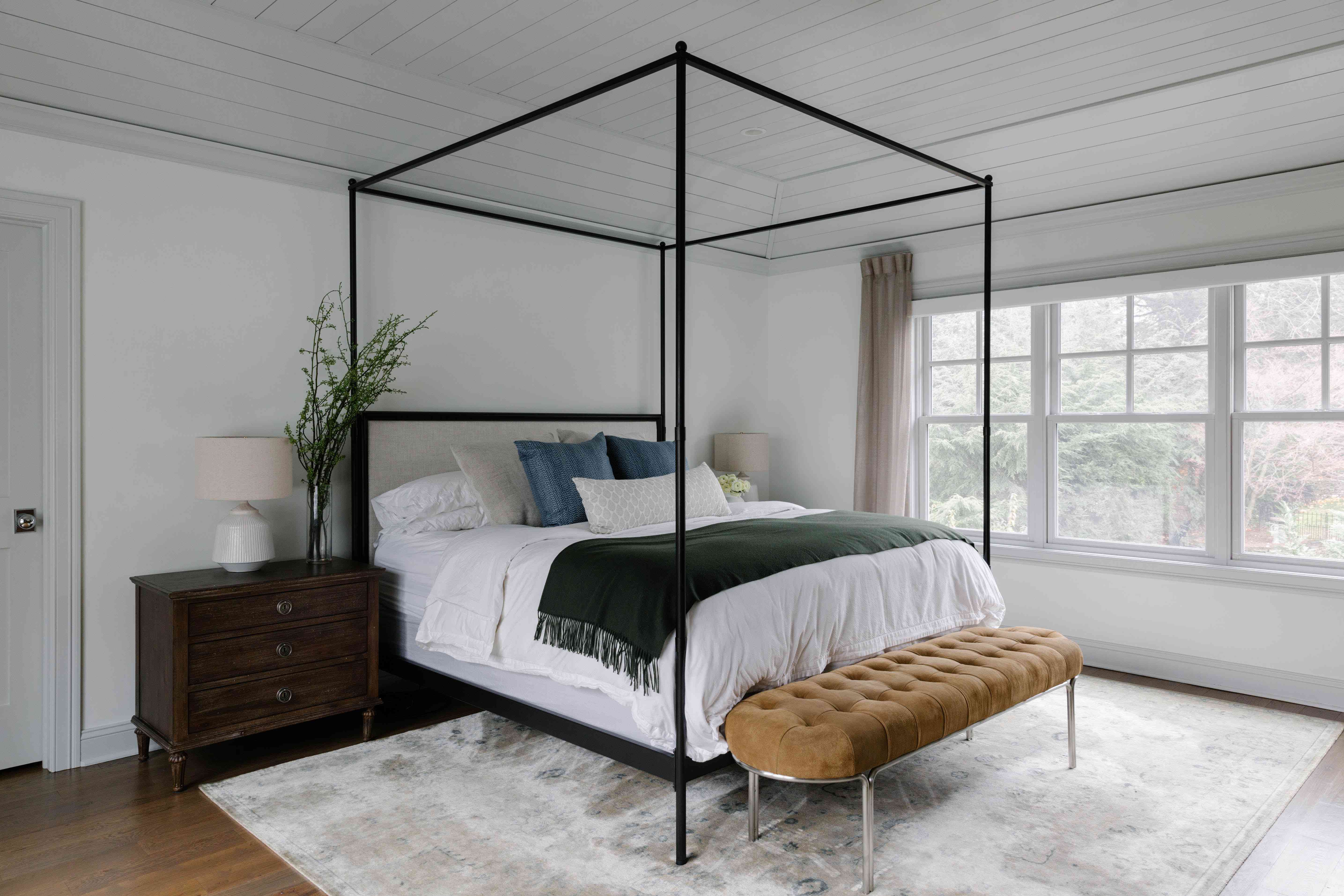 天篷床与中性地毯和被褥。