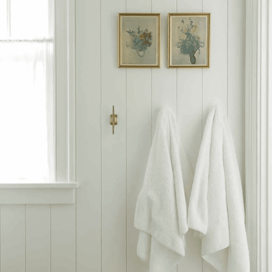 一个有木板衬里的浴室，装饰着两幅古老的小画