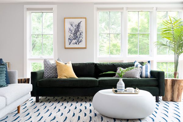 海滩房子客厅与棕榈和绿色沙发。＂class=