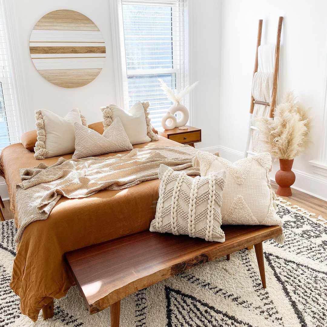 波西米什风格卧室，带纹理中性枕头和毯子。