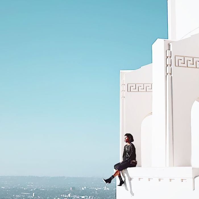 一个女人坐在一栋俯瞰洛杉矶东区的建筑物的窗台上