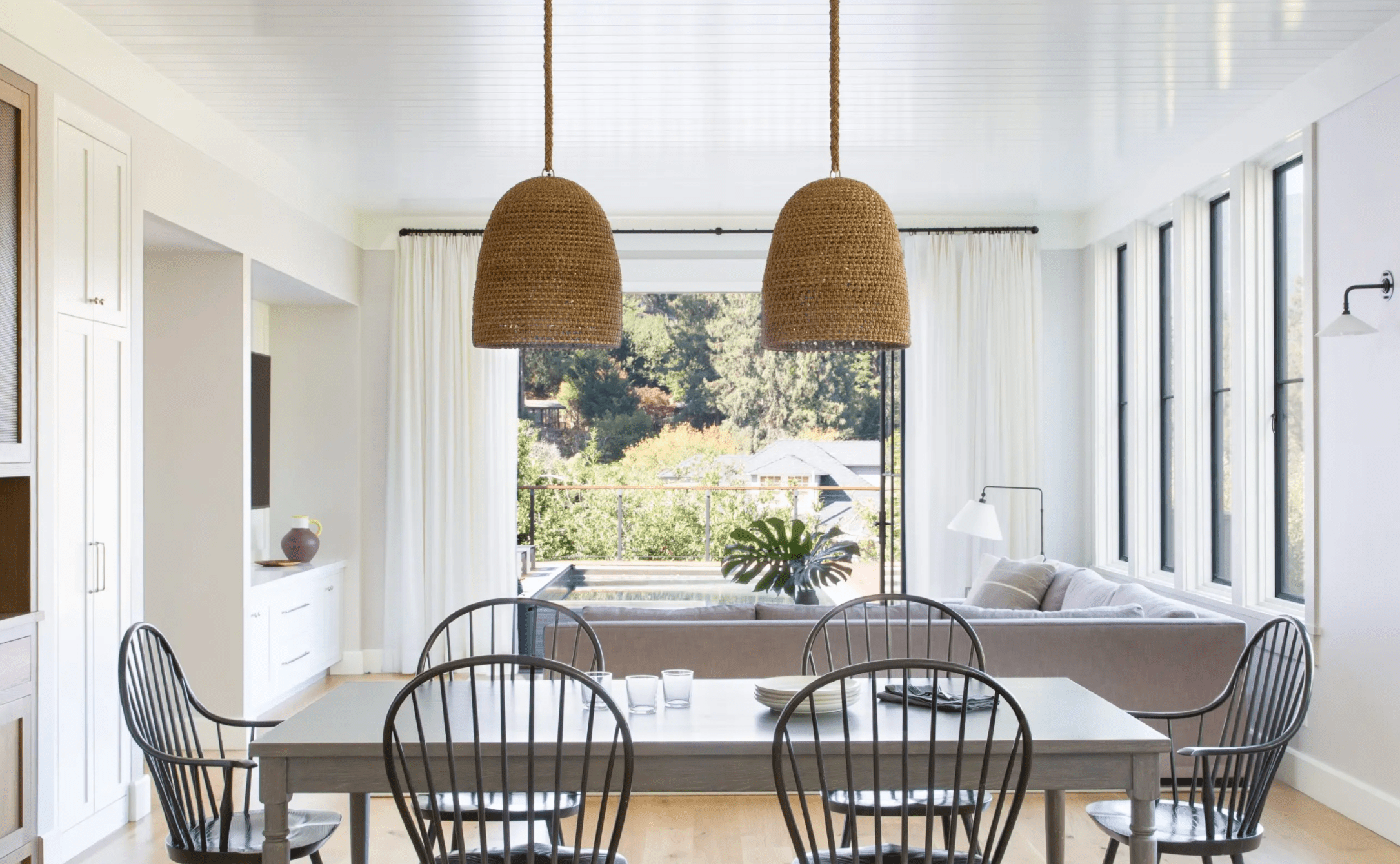 餐桌上有三个玻璃杯、一堆盘子和几块餐巾布