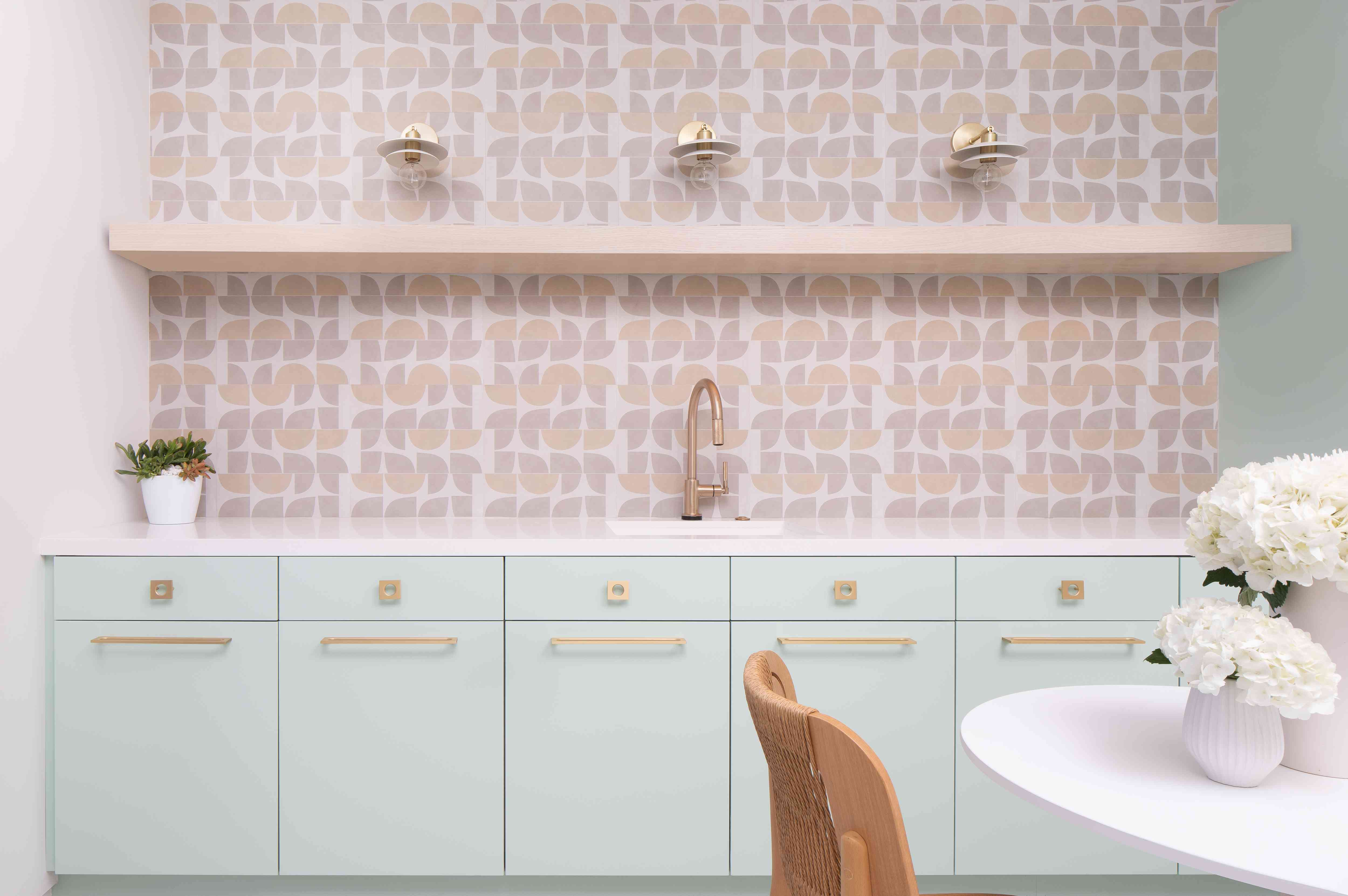 薄荷的绿色橱柜和粉红色的瓷砖背板。