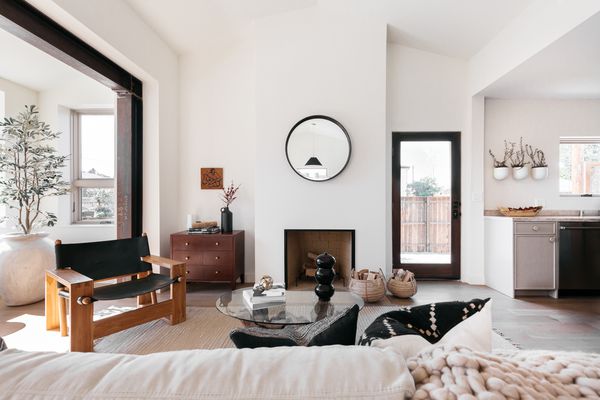 中性的客厅，配有皮椅和圆形镜子。