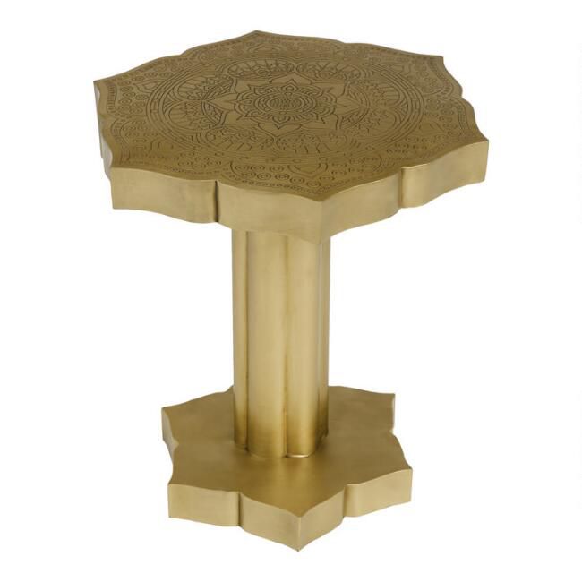 一种顶部有复杂雕刻的花形黄铜桌子。