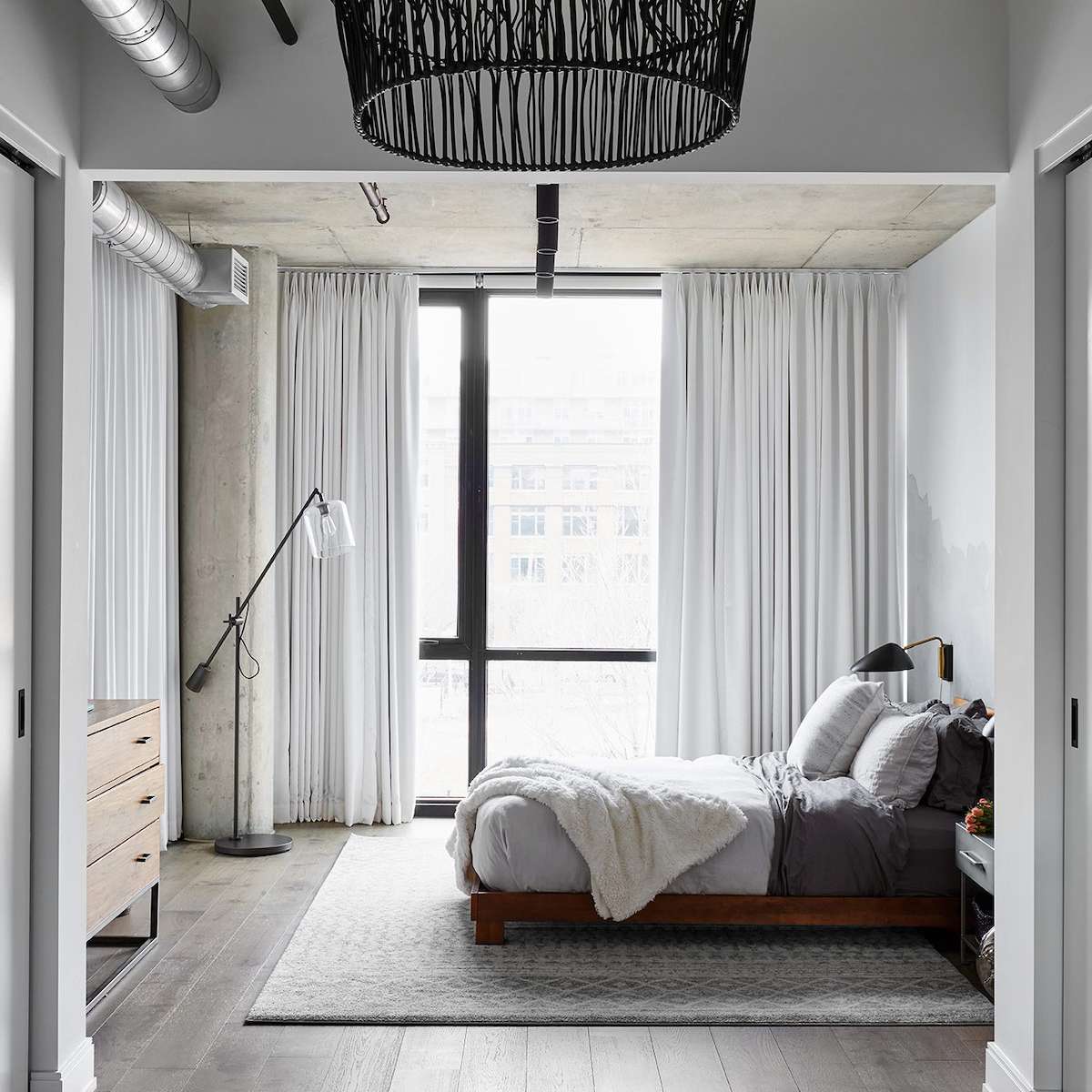 工业卧室配有编织的枝形吊灯，现代的缝业和工业落地灯