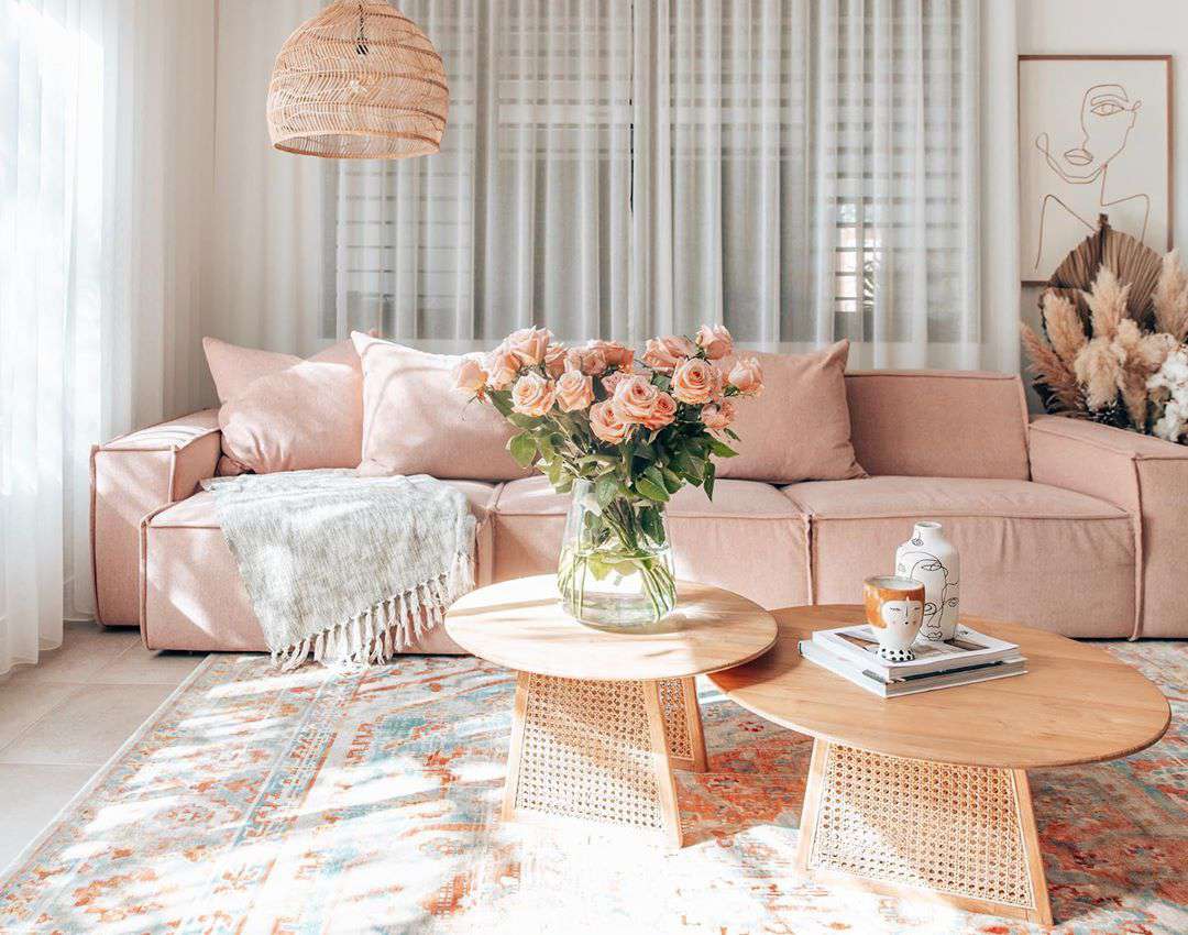 粉红色的沙发和两张咖啡桌。