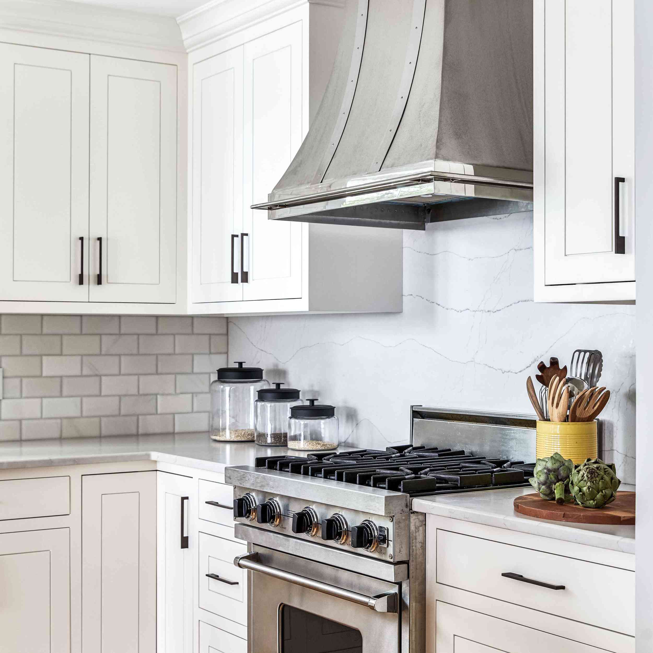 厨房里有两个白色挡板:一个是用瓷砖做的，另一个是用大理石做的