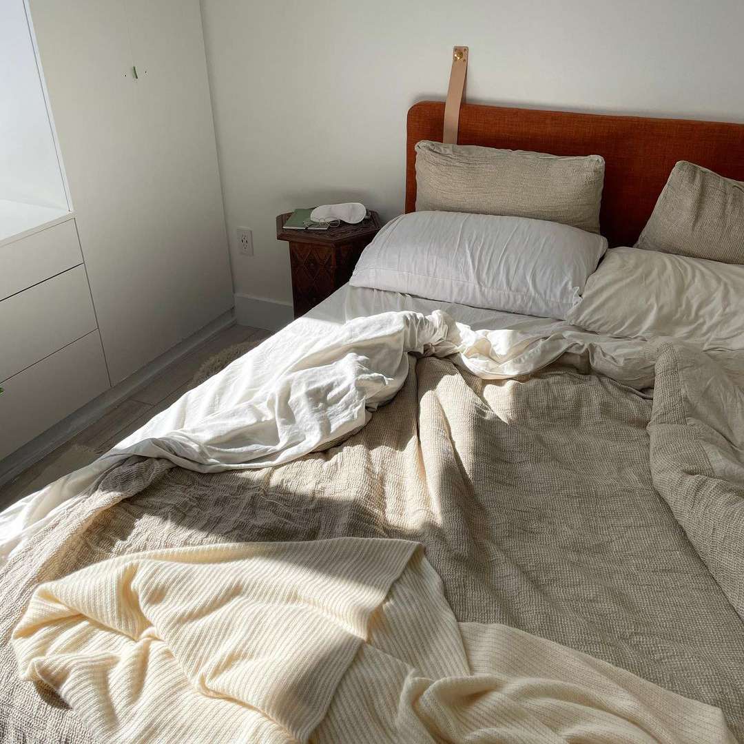 白色和棕色床单的凌乱床。