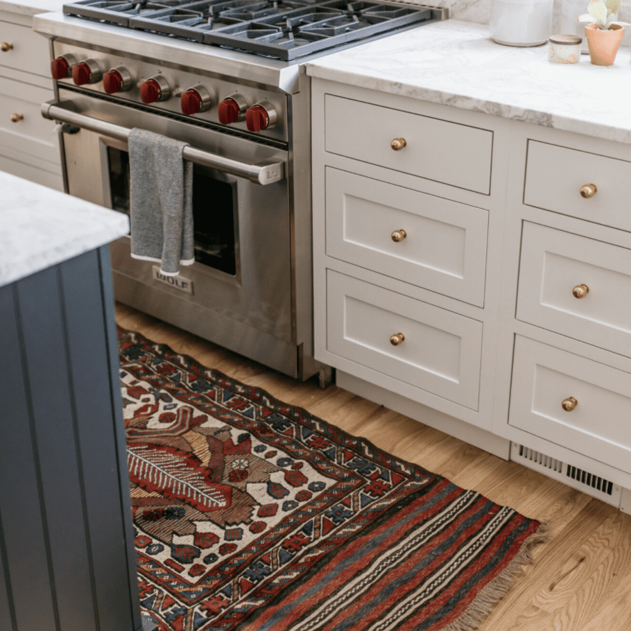 白色的厨房里铺着深红色的地毯