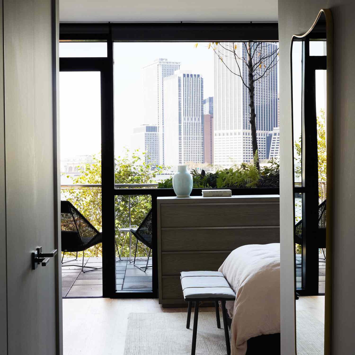 通往阳台的卧室装饰着大胆的黑色椅子
