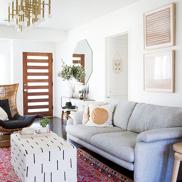 客厅里铺着红色印花地毯，条凳当咖啡桌”class=