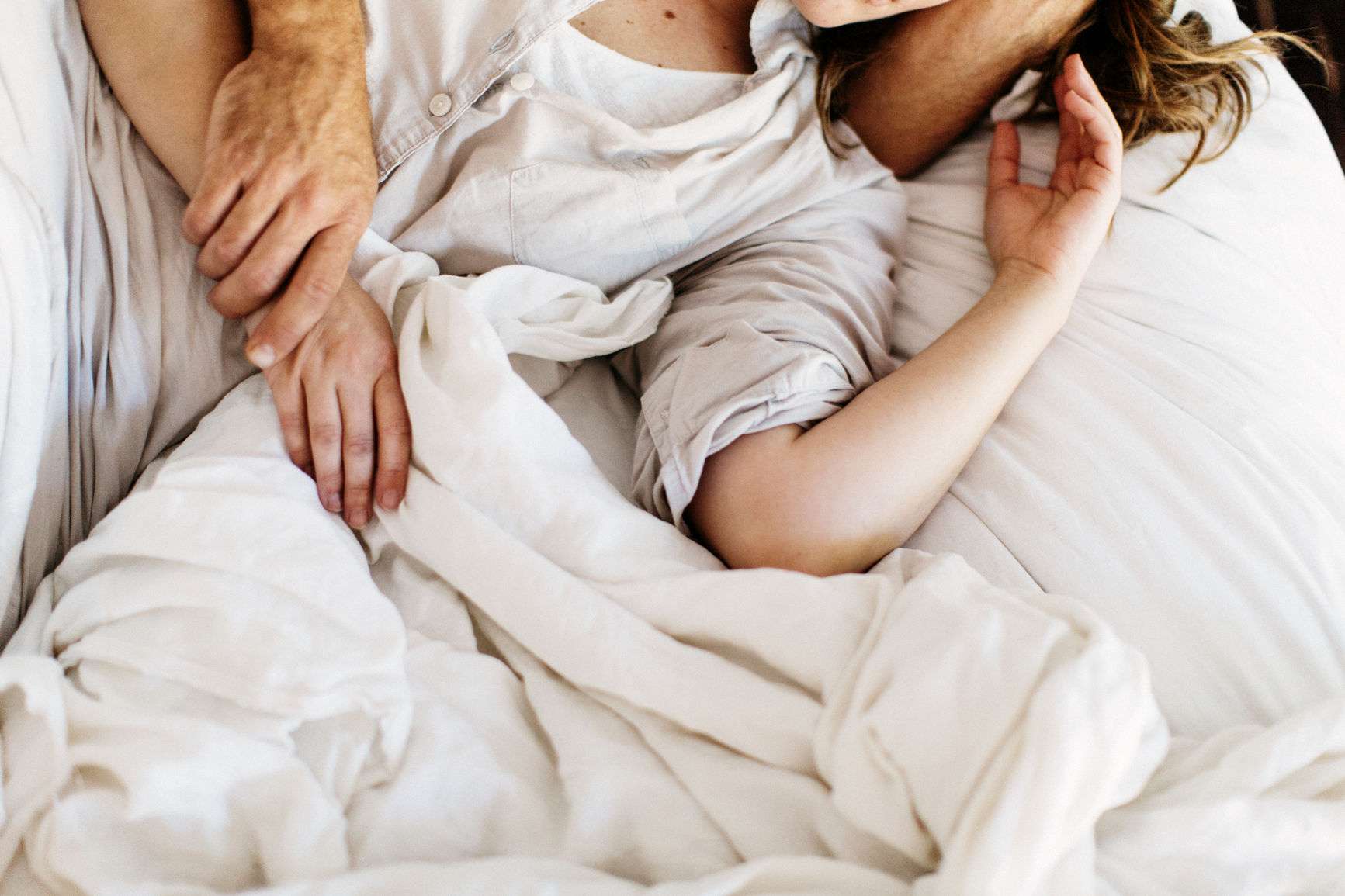 夫妇在床下面的床上搂着彼此