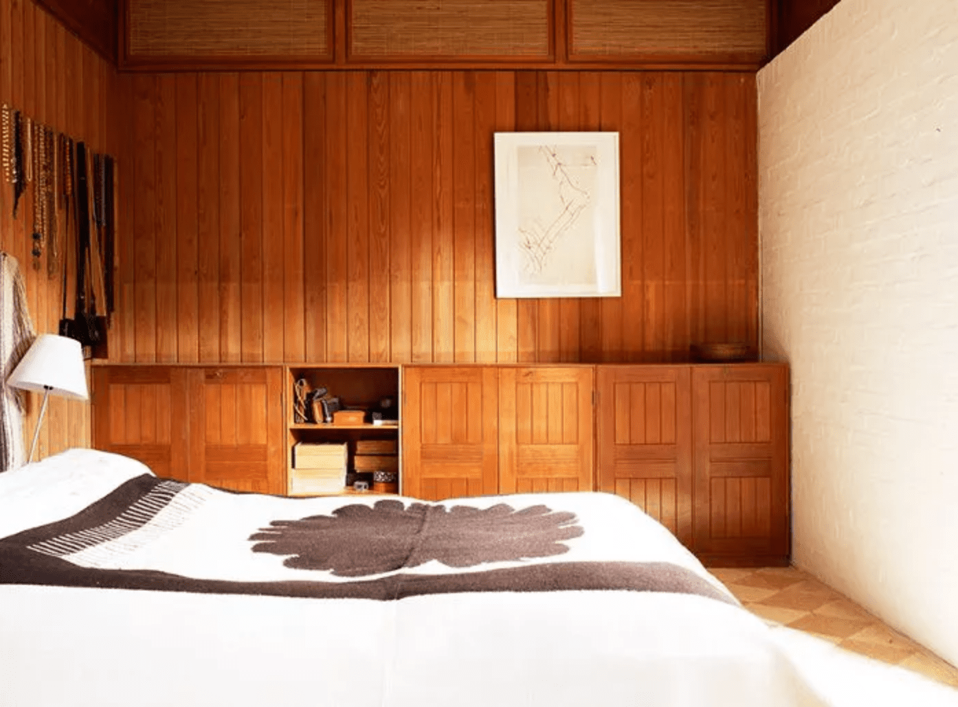 昏暗的灯光和木镶板的墙壁在一个装饰稀疏的卧室