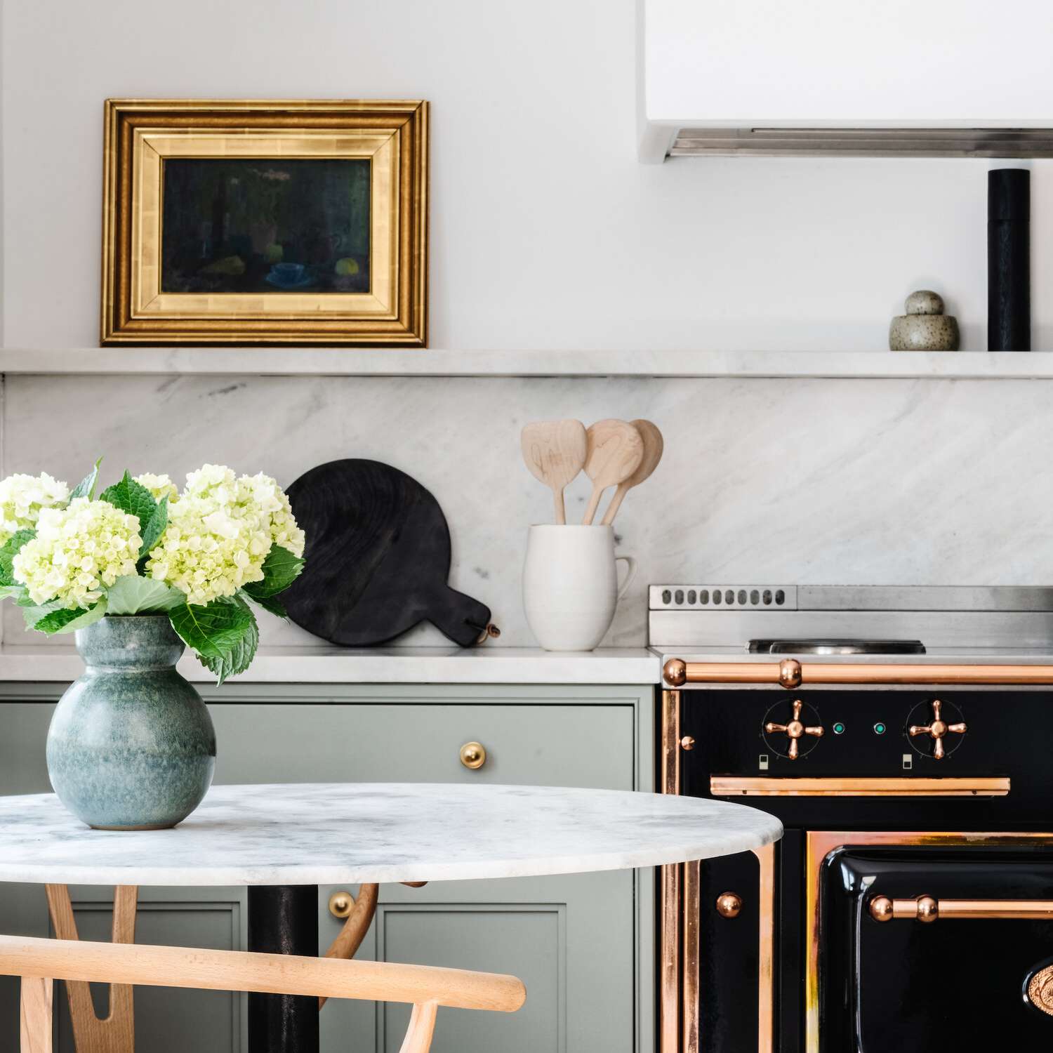 一个有薄荷橱柜、黑烤箱和电炉的厨房