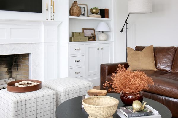 客厅里有黑色的桌子，两张椅子，棕色的皮沙发。